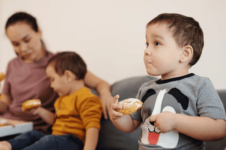 2 children eating donuts