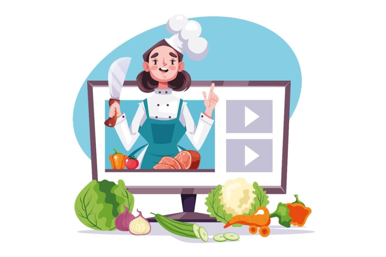 Illustration of a smiling chef wearing a toque on a computer screen holding a knife and teaching cooking, with assorted vegetables and cuts of meat arranged in front of the monitor. 