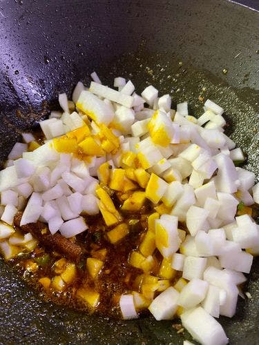 White Radish chunks tempered in a wok.