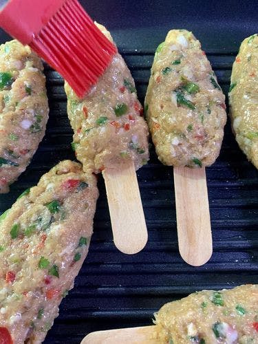 Grilled-Chicken-Kebab-Brushing-Oil-on-Threaded-Chicken-Mince-Sticks.jpg