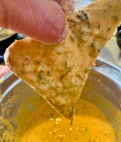 Excess flour mixture draining from a triangular piece of bread.