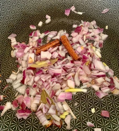 Chopped onions and spices being tempered