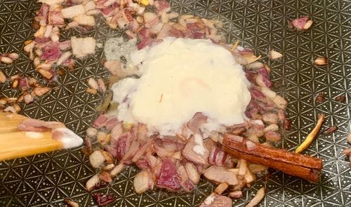 A dollop of yogurt on chopped onions and spices