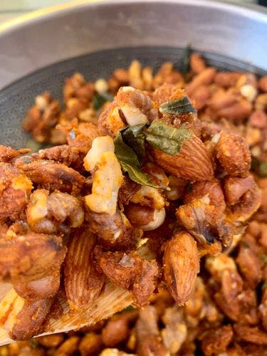 Jaggery coated nuts mixture in a pan