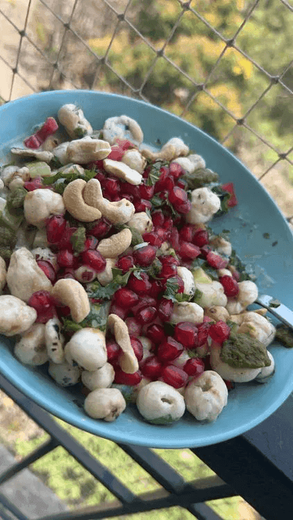 A close-up of a plate containing Savory Foxnut Mix with foxnut, cashews and pomegranate seeds.