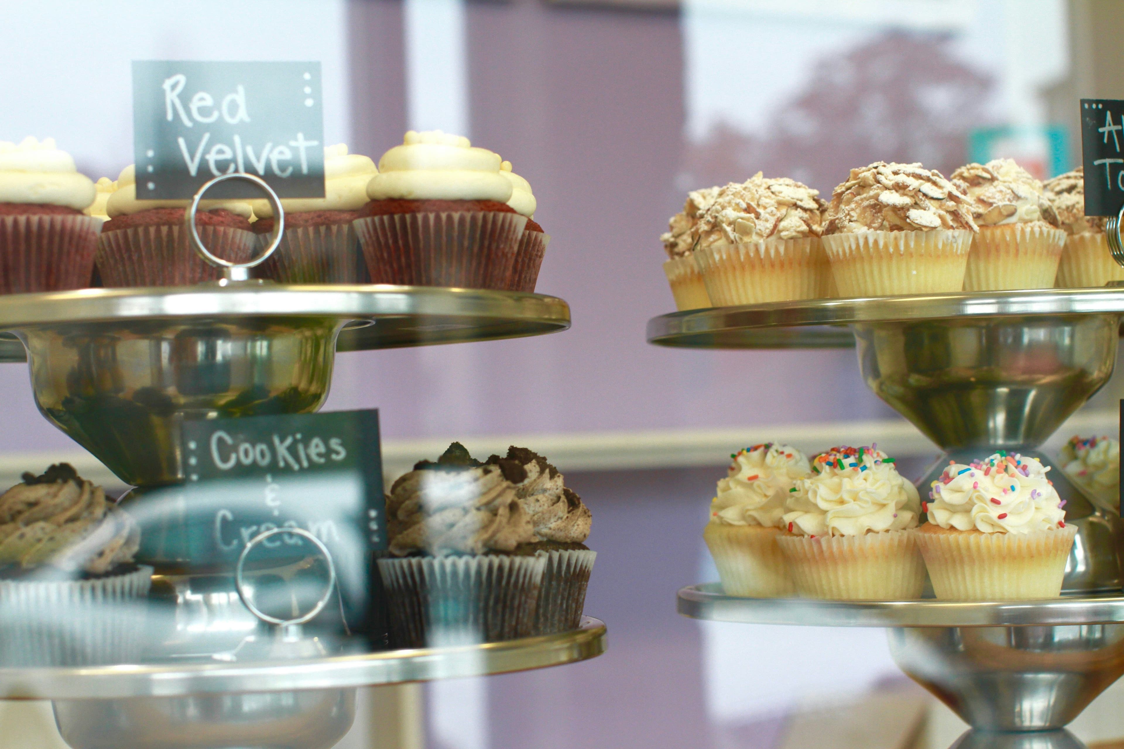 Several delicious desserts placed in the display of a bakery