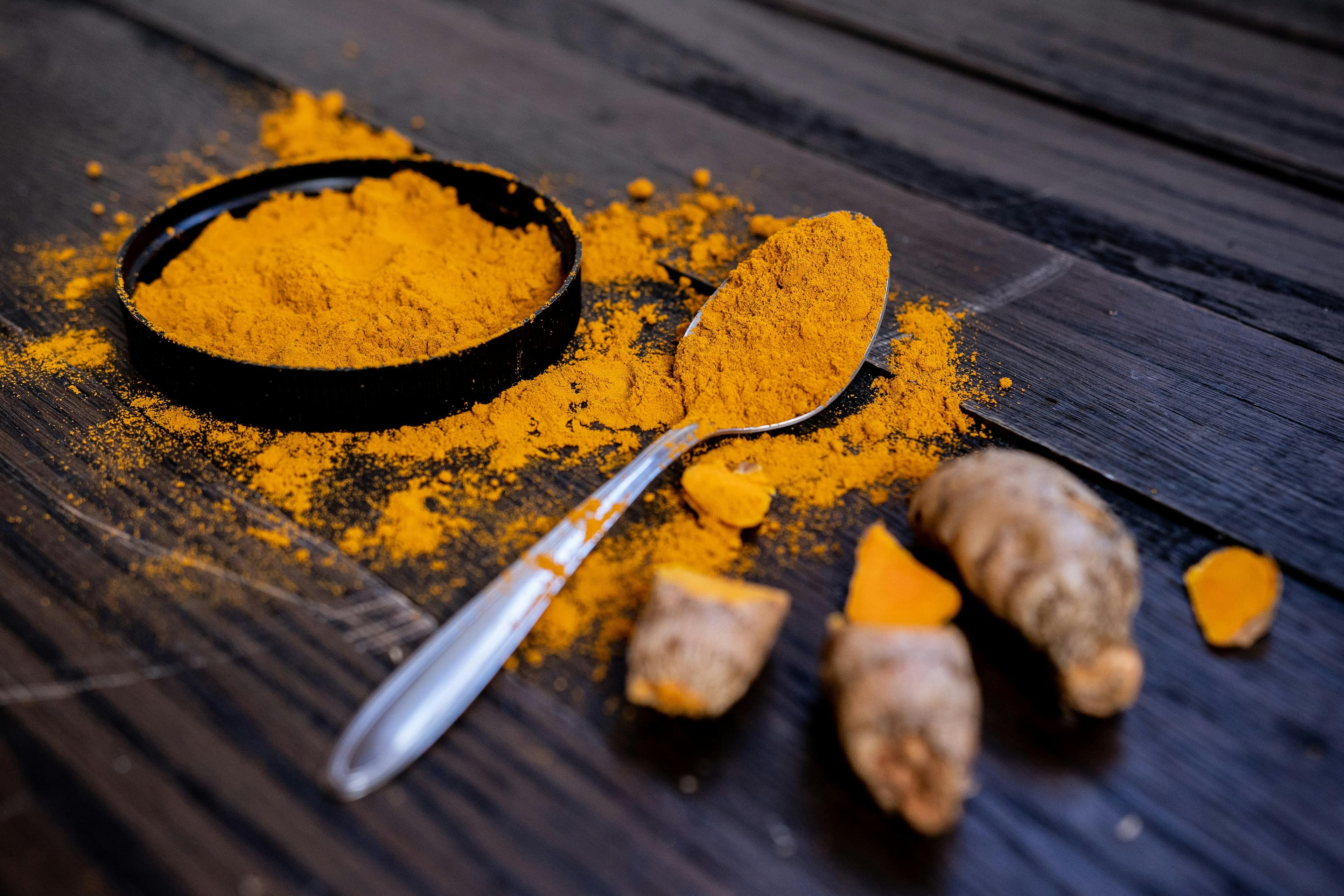 Whole turmeric and powdered turmeric placed beside each other