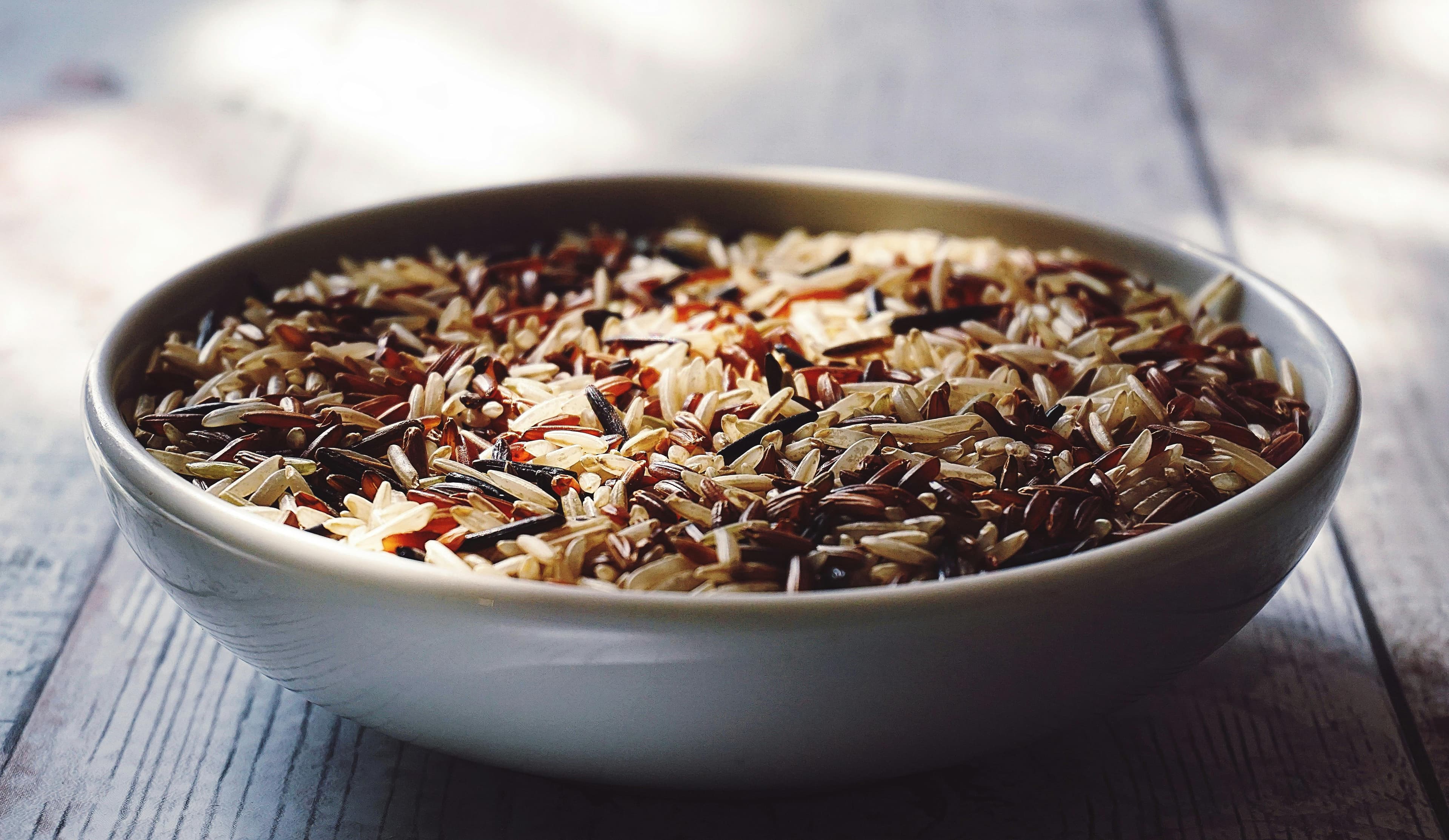 Brown rice grains placed neatly in a wide bowl.