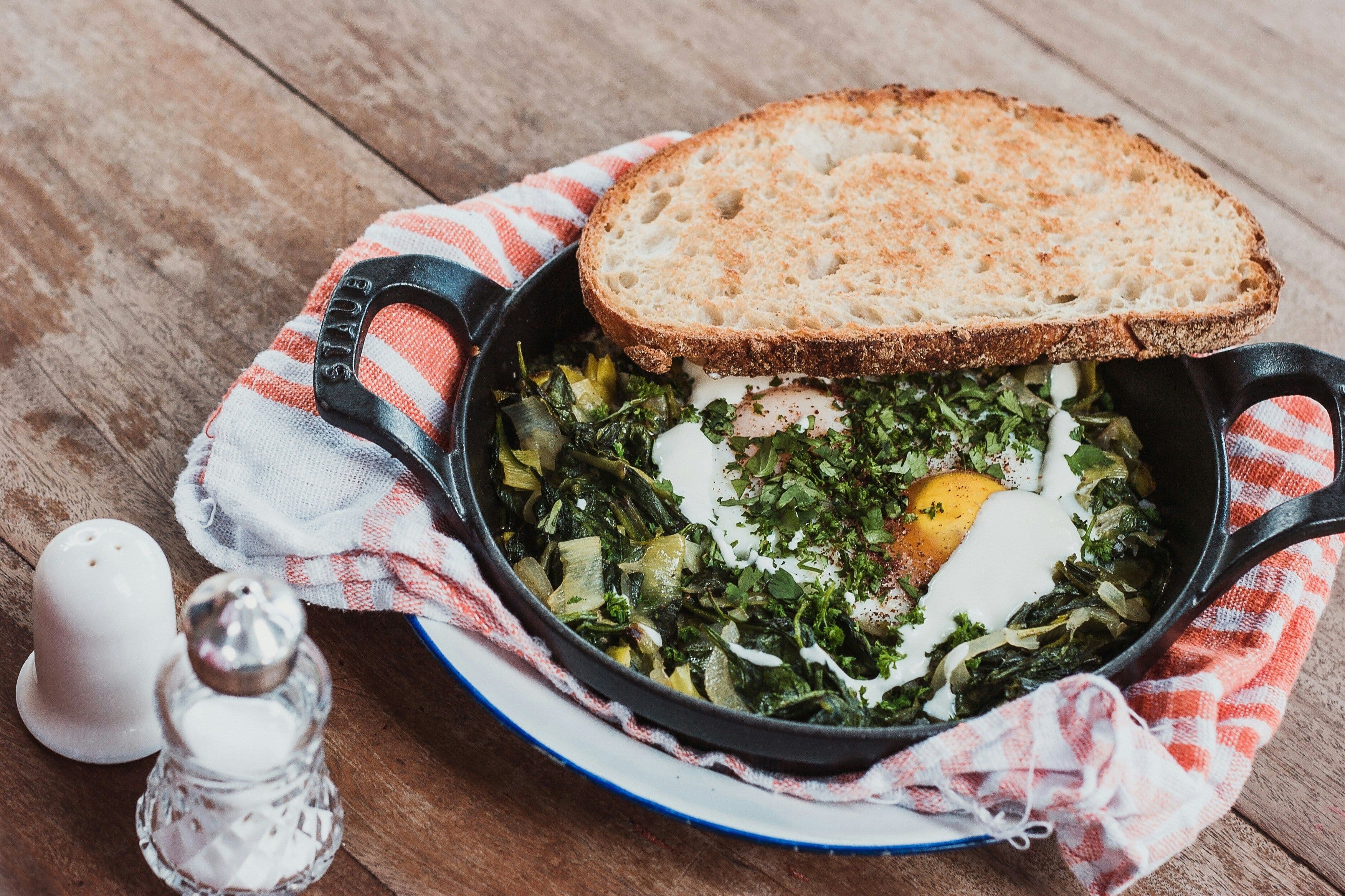 A cast iron utensil containing freshly made eggs.