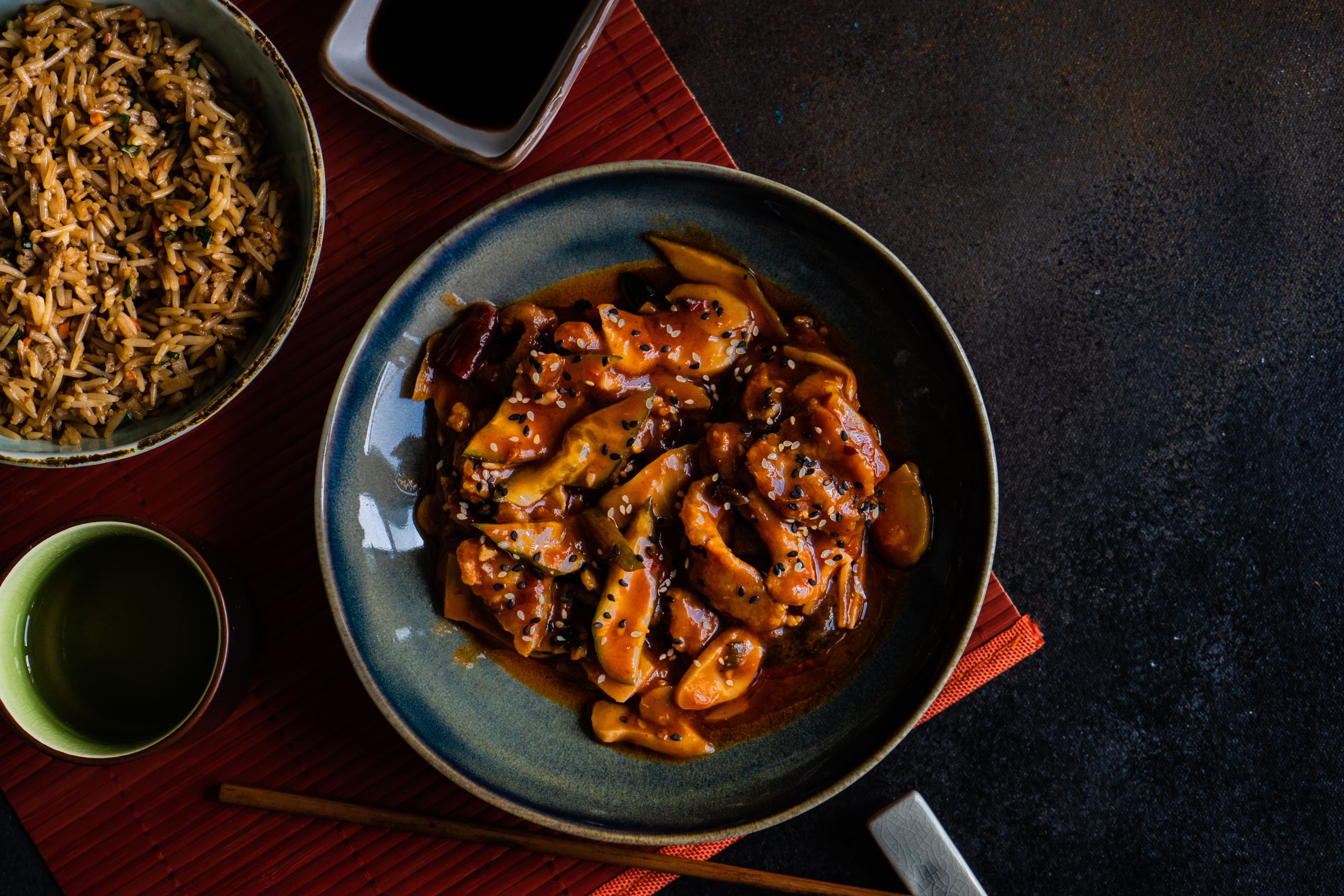 Glazed chicken teriyaki served with rice, topped with sesame seeds.