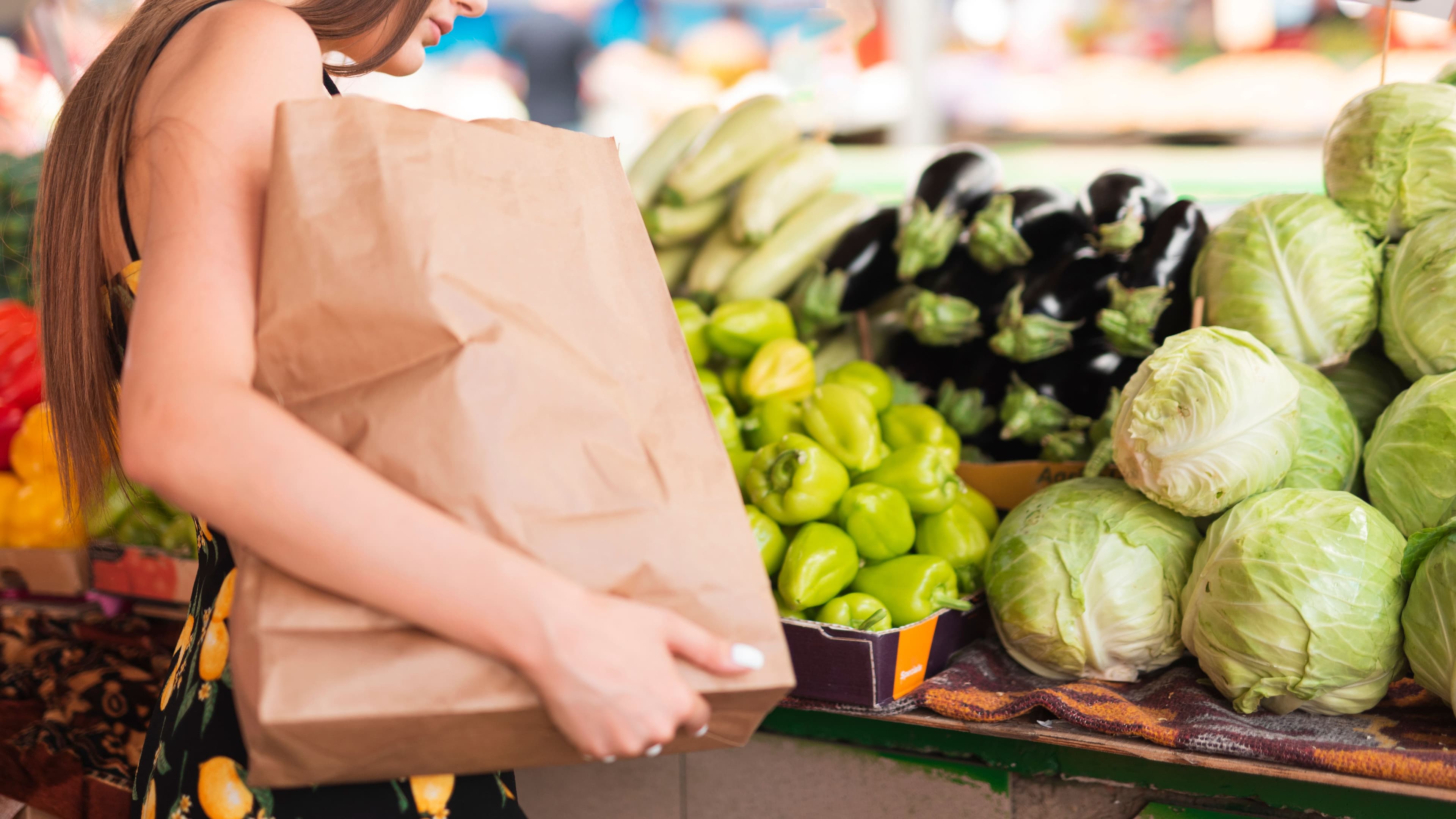 Woman selecting fresh produce while shopping with a zero-waste kitchen mindset