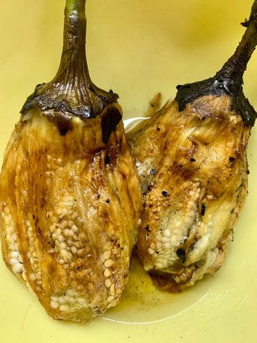 Two roasted eggplants with skin removed. 