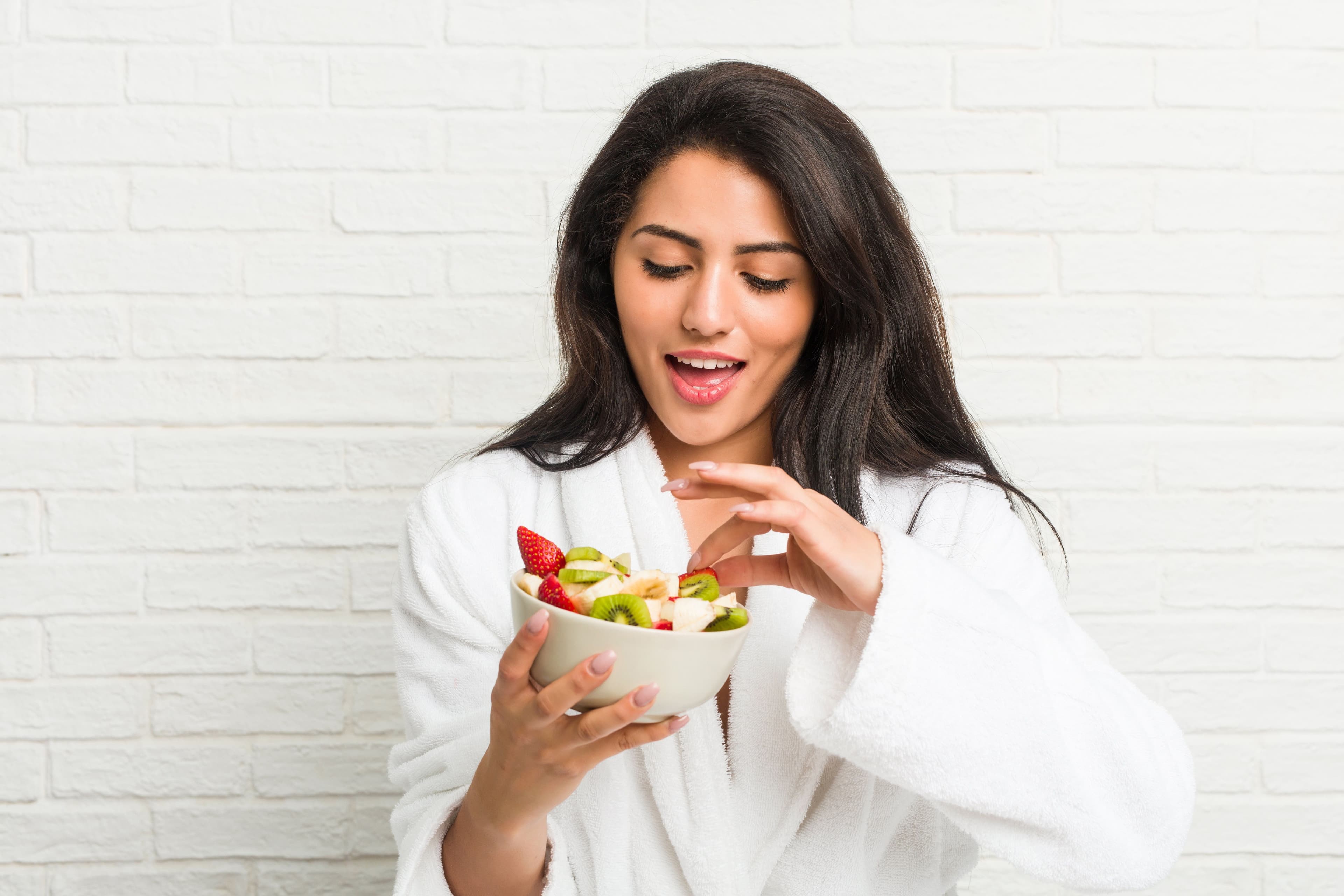 Smiling woman enjoying a healthy homemade snack.