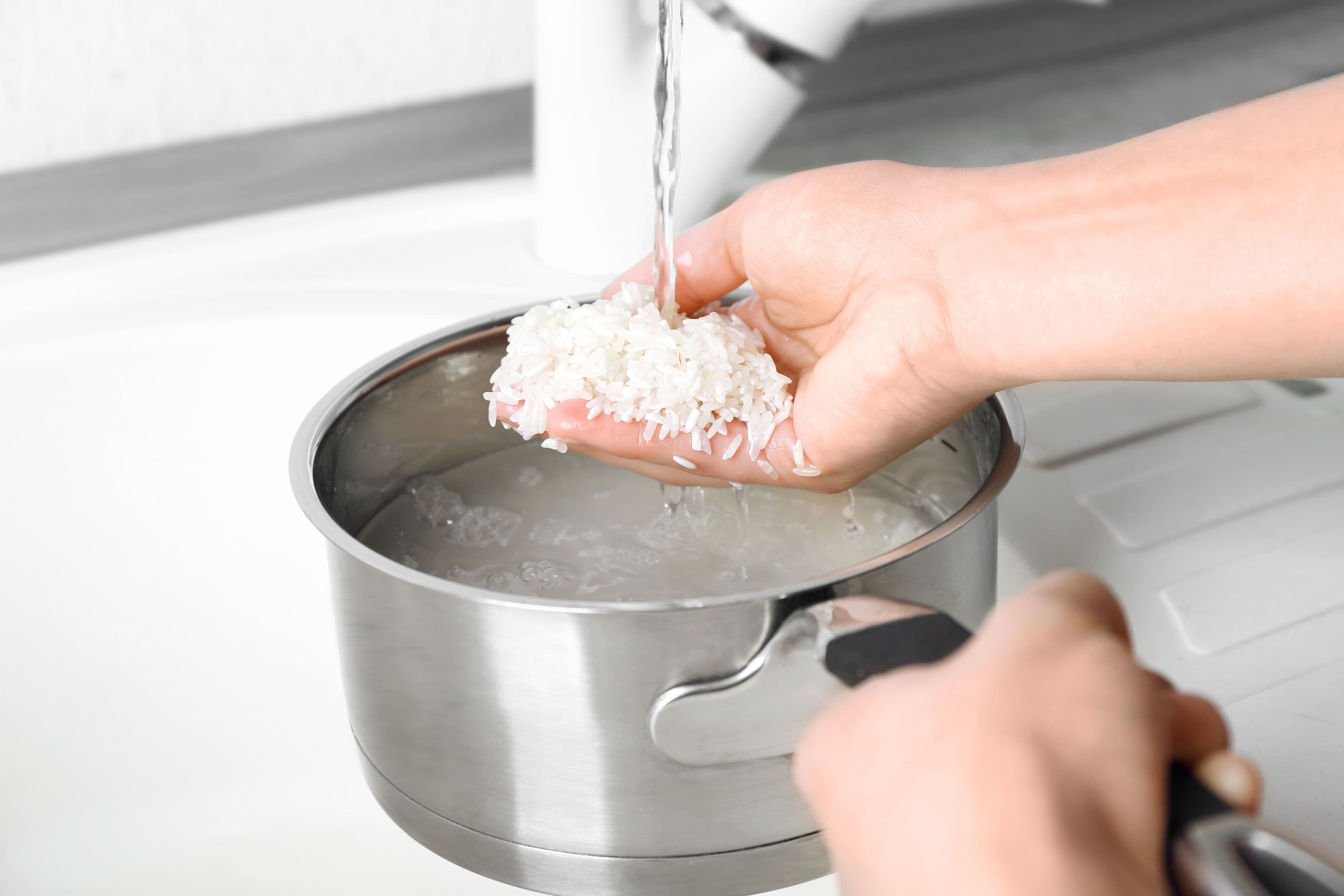 woman-rinsing-rice-saucepan-running-water